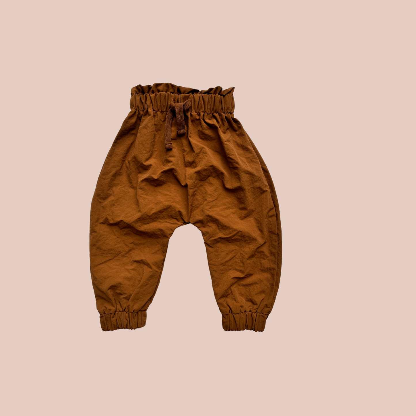 100% recycled nylon water resistant rain pants, lightweight and quick drying harem style leg with elastic waist and ankle, signature inbuilt pocket