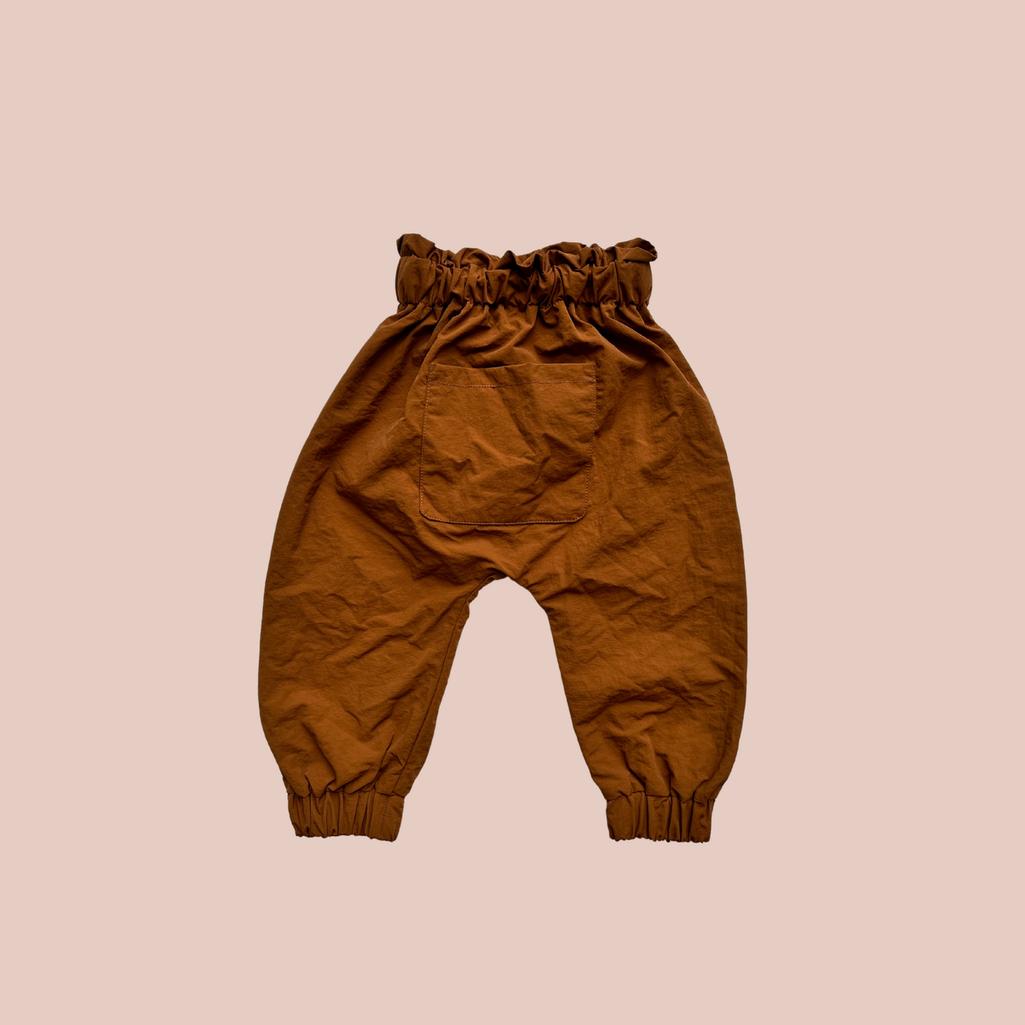 100% recycled nylon water resistant rain pants, lightweight and quick drying harem style leg with elastic waist and ankle, signature inbuilt pocket