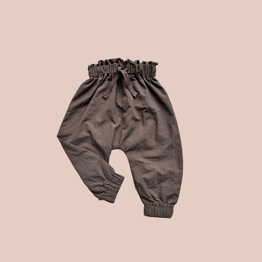 100% recycled nylon water resistant rain pants, lightweight and quick drying harem style leg with elastic waist and ankle, signature inbuilt pocket